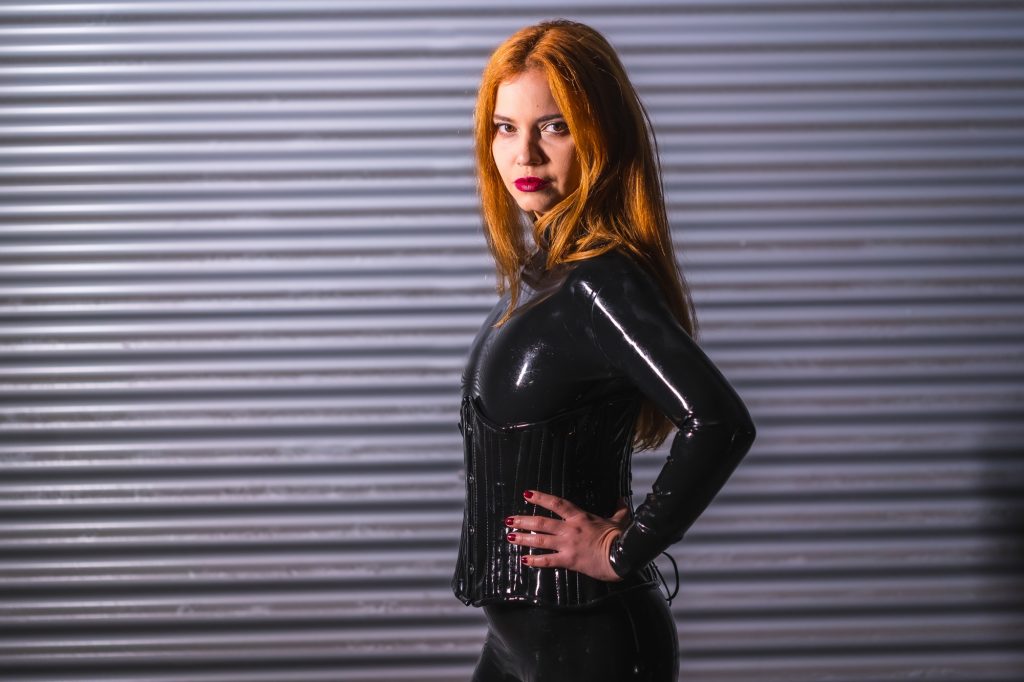 Redhead girl in latex, a black top and tight pants
