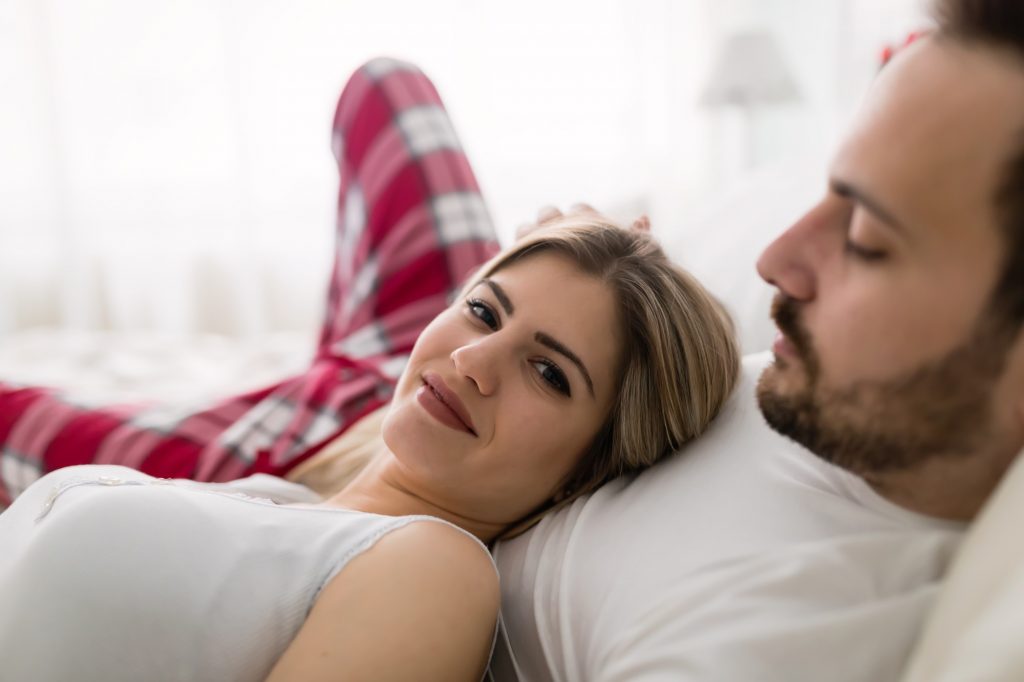 Young attractive couple having romantic time in bed